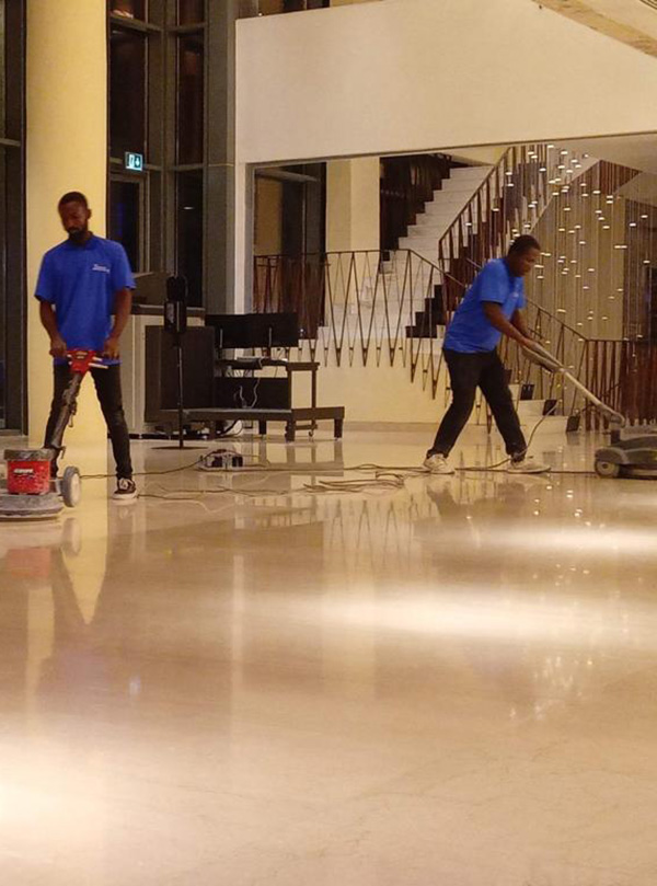 Two KAB Cleaning Services operatives polishing a hotel lobby floor